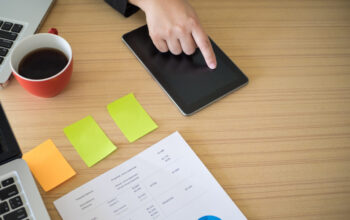 Tablet computer in men hands. Man presses on the blank screen tablet computer. Concept man working from home using tablet computer. Free space for text. Top view. Copy space.